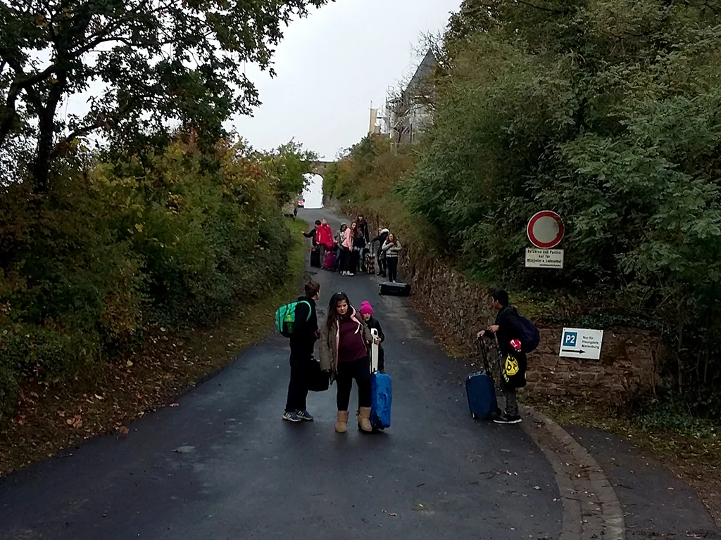 Gruppe steht mit Koffern auf der Straße vor der Abreise.